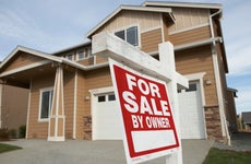 'For Sale' sign in front of house