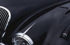 a black jaguar sports car hood showing a grill and headlight