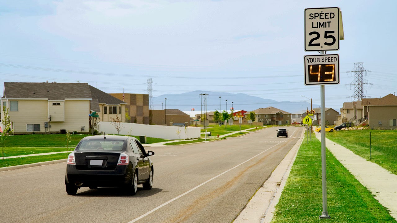 car speeding by a speed limit sign and radar