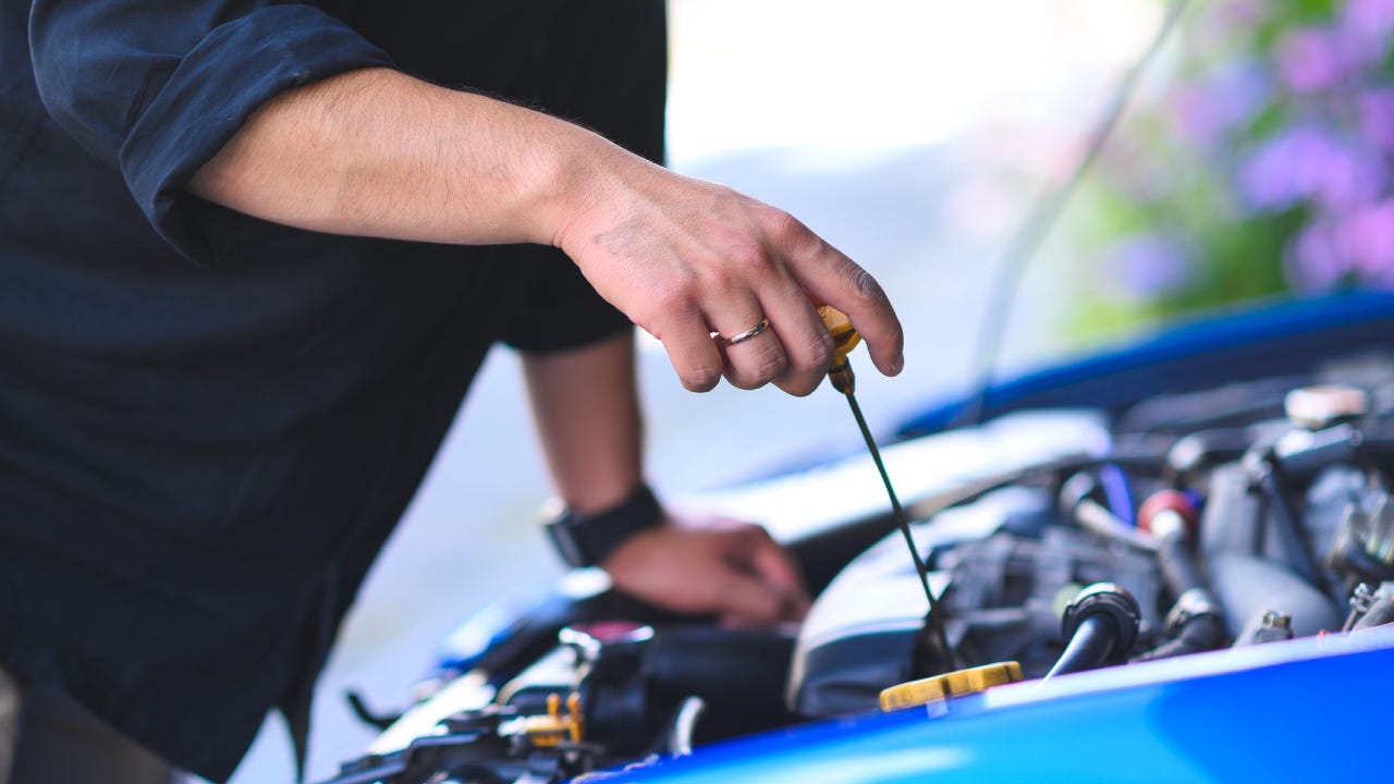 Cropped Hands Of Mechanic maintain car, engine oil check and replace