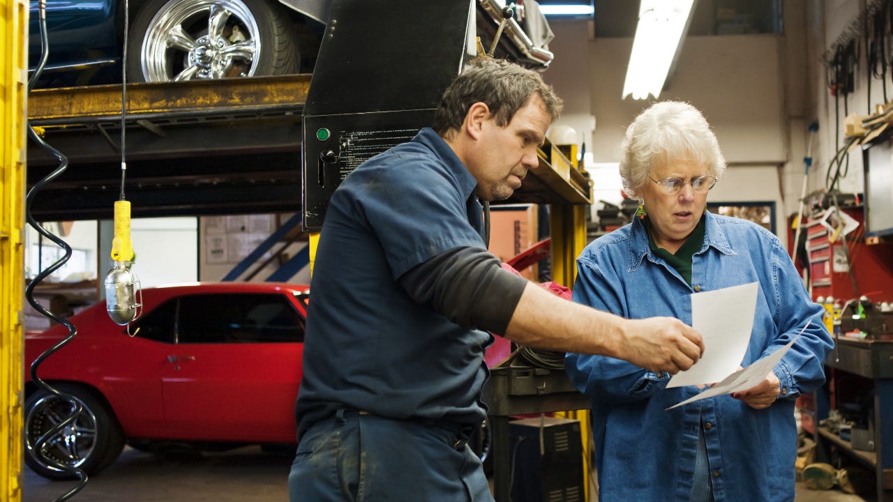 A mechanic discusses a bill with a customer