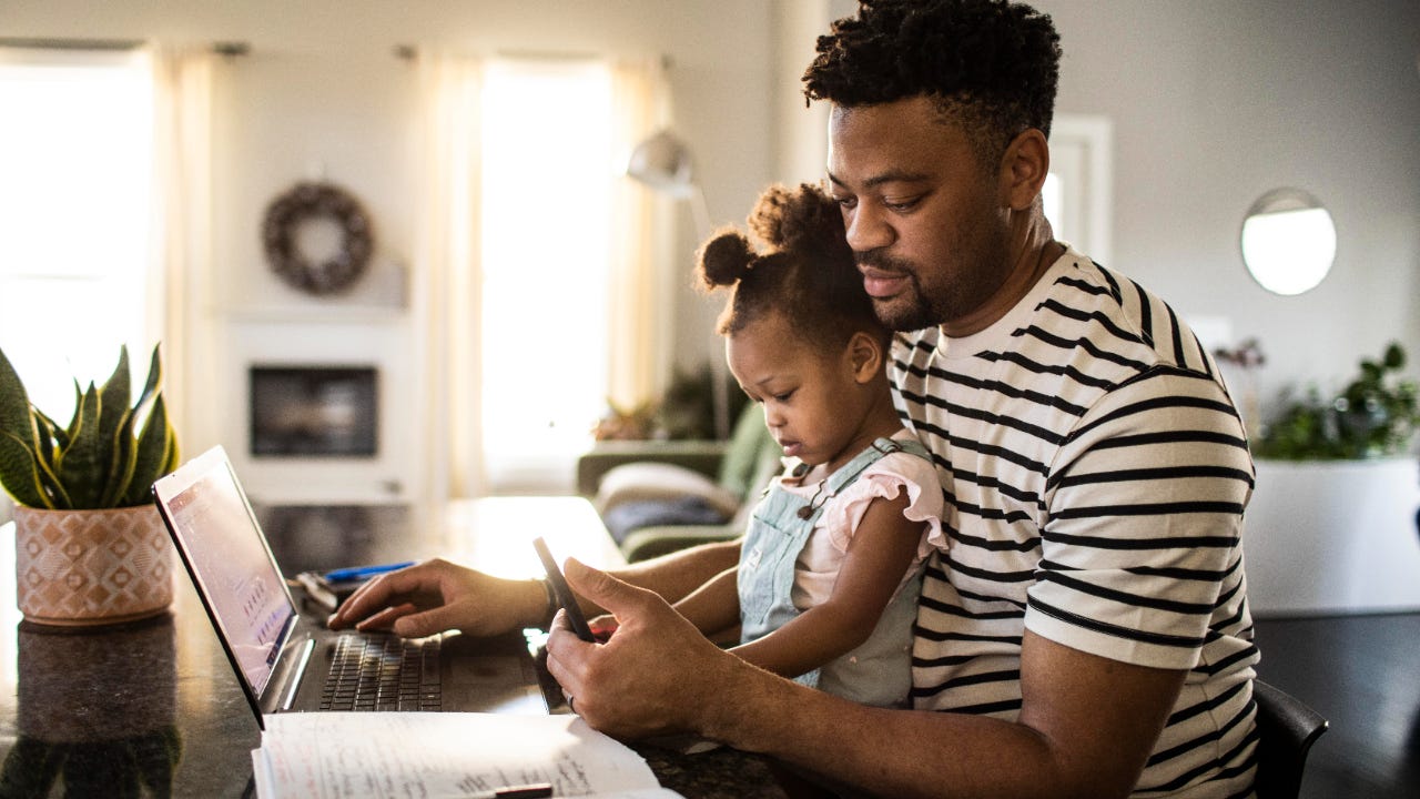 Man with baby at computer.