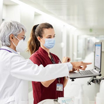 A doctor and nurse consult in front of a computer