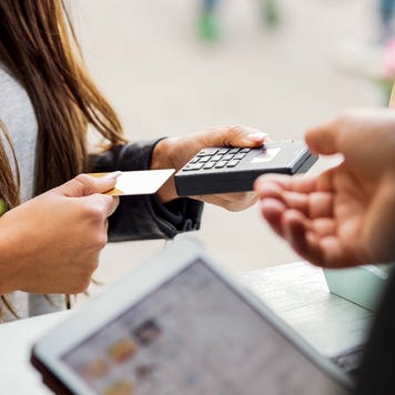 a person inserting a credit card into a hand held card reader