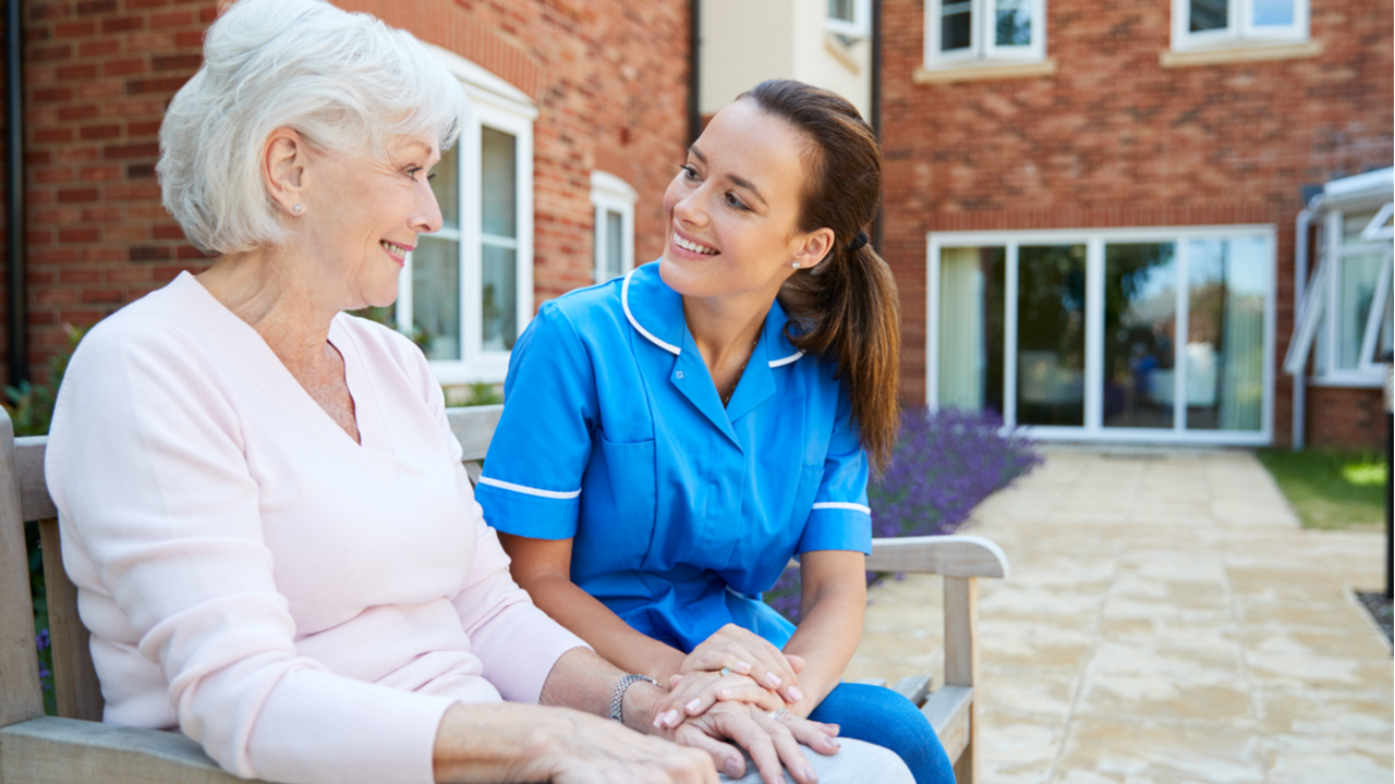 Nurse talks with a woman in a retirement home