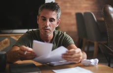 A worried man looks through bills