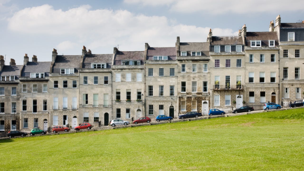 Cars parked outside Georgian terraced town houses that form the Royal Crescent in the city of Bath, Somerset