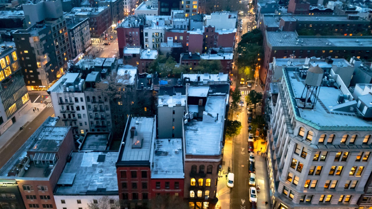Overhead view of the busy streets of Nolita and SoHo neighborhoods with colorful night lights shining at dusk in Manhattan, New York City NYC