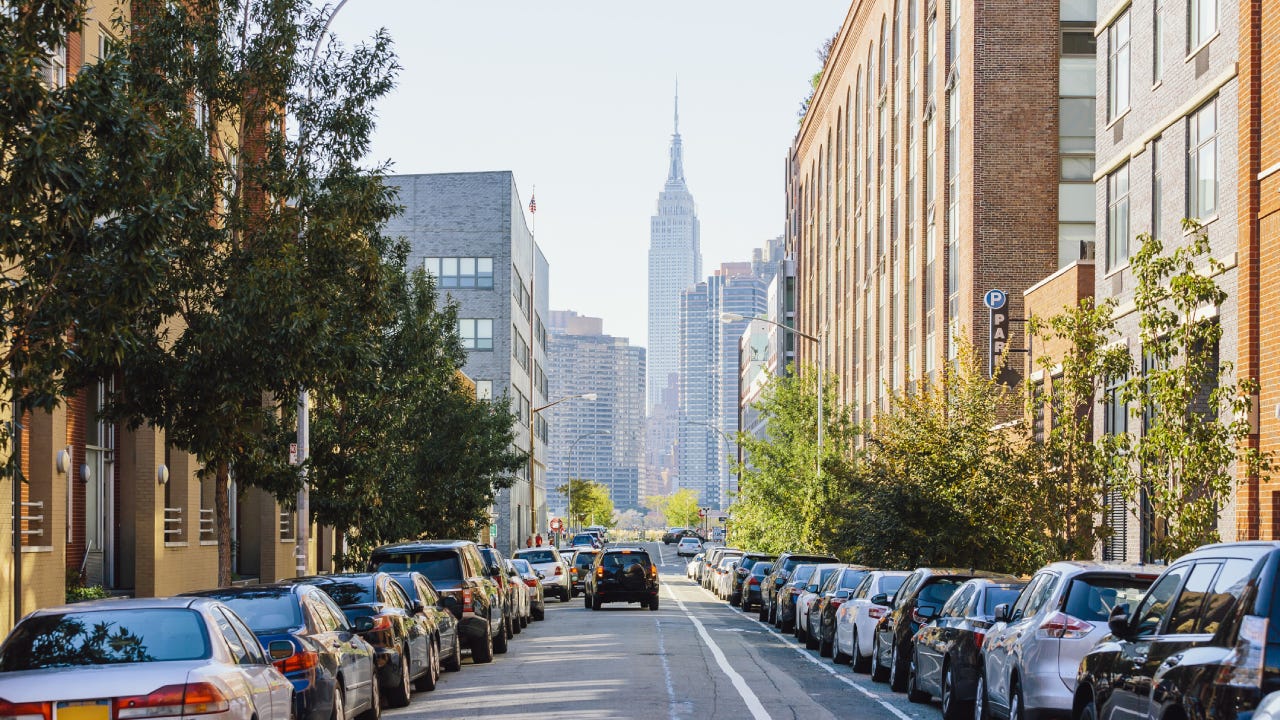 Street in Queens and Empire State Building in the center, New York City, USA