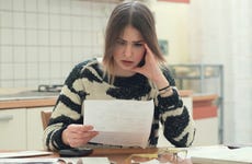 A worried woman looks at bills