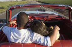 Hispanic couple driving in convertible