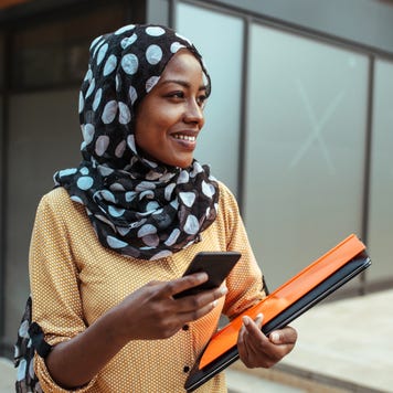 Young woman with phone and folders