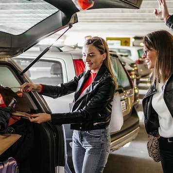 friends putting luggage in a car