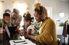 Woman working from home with husband and children
