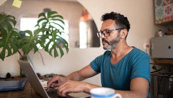 Man on laptop with mug