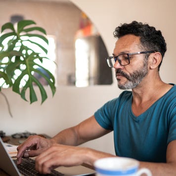 Man on laptop with mug