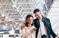 Couple at airport looking at smartphone