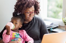 Mother working on laptop with toddler