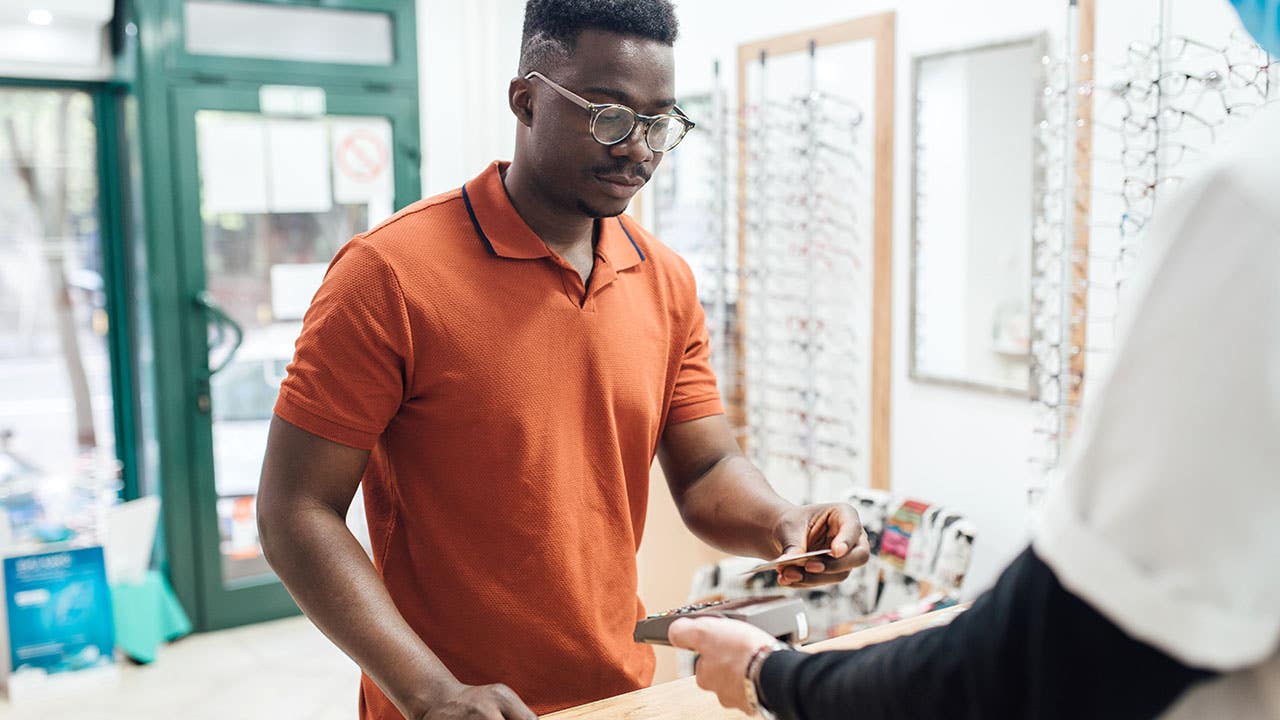 man paying bill at a glasses shop