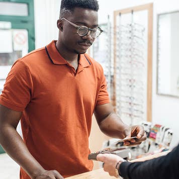 man paying bill at a glasses shop