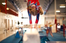 Young Gymnast Doing Handstand on Balance Beam