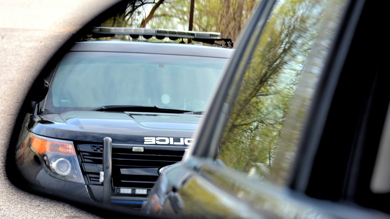 A police car has a motorist stopped for a violation. the drivers