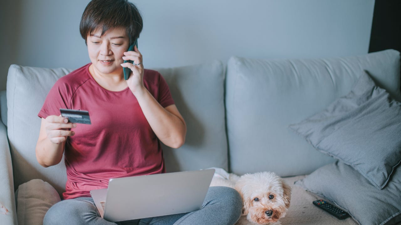 Woman with dog and credit card and laptop