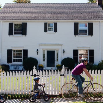 Family biking outside of suburban home