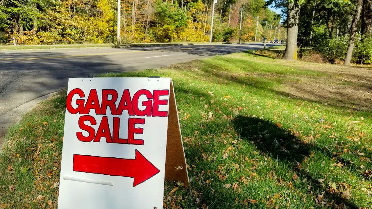 Garage sale in grass on street curb with autumn trees background