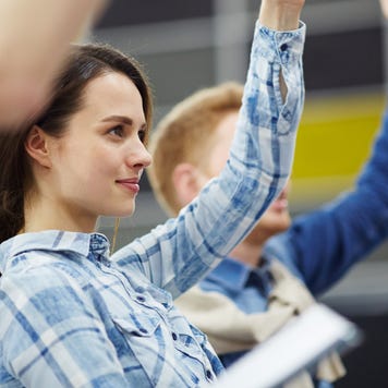 College student raises a hand in a class