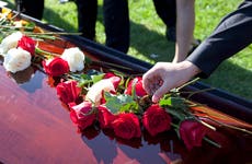 shot of roses and flowers on top of coffin