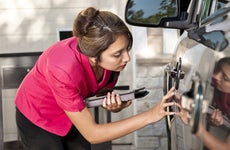 Automobile insurance adjuster inspecting damage to vehicle