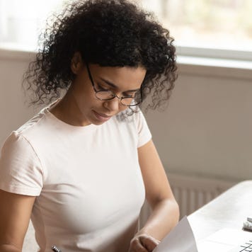 Concentrated young african american business woman signing documents