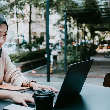 Young woman working at coffee shop on laptop