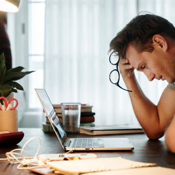 Stressed man looks at his laptop.