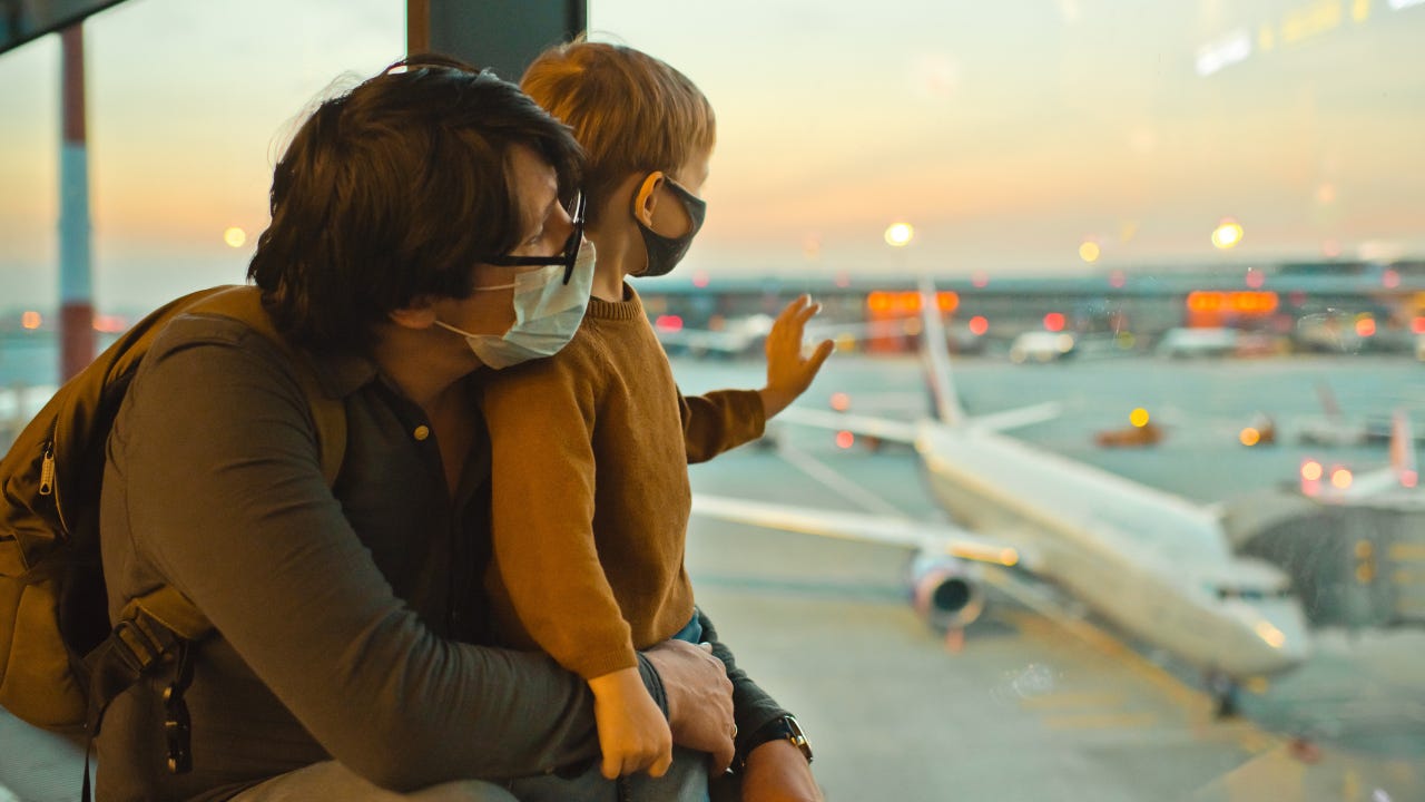Father and son at airport wearing masks