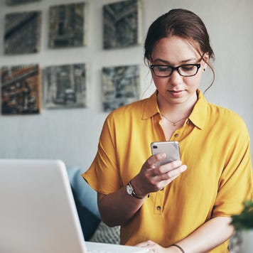 Woman on smartphone and laptop