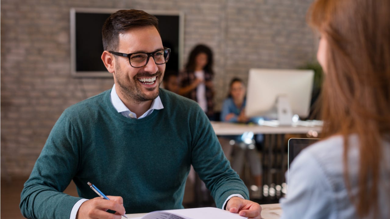 Smiling man conducts an interview