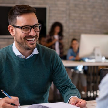 Smiling man conducts an interview