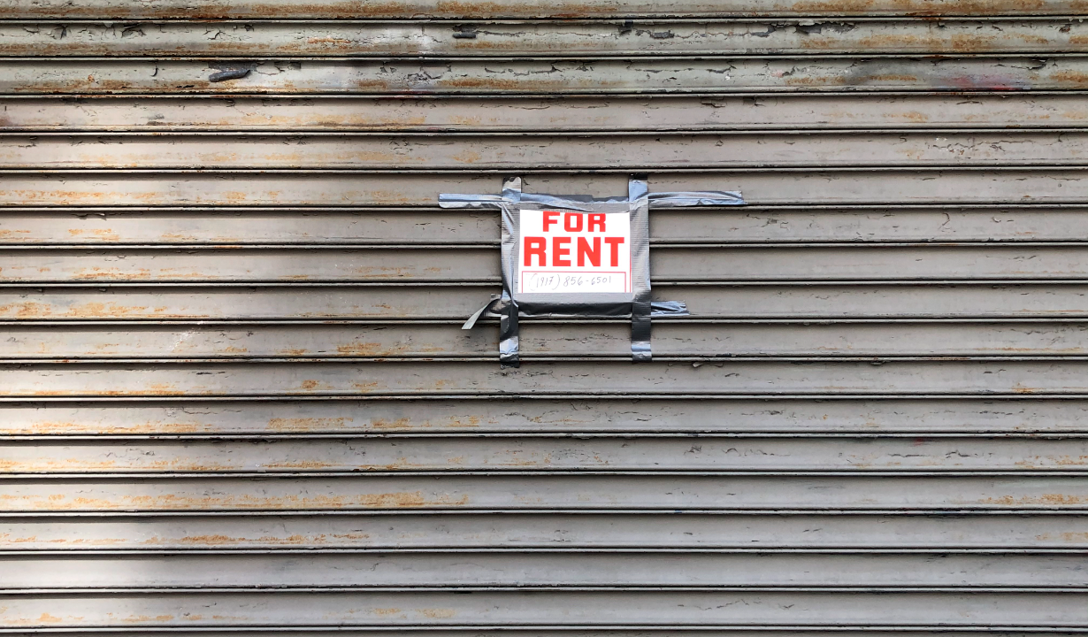 For Rent sign taped on gated storefront, Queens, New York