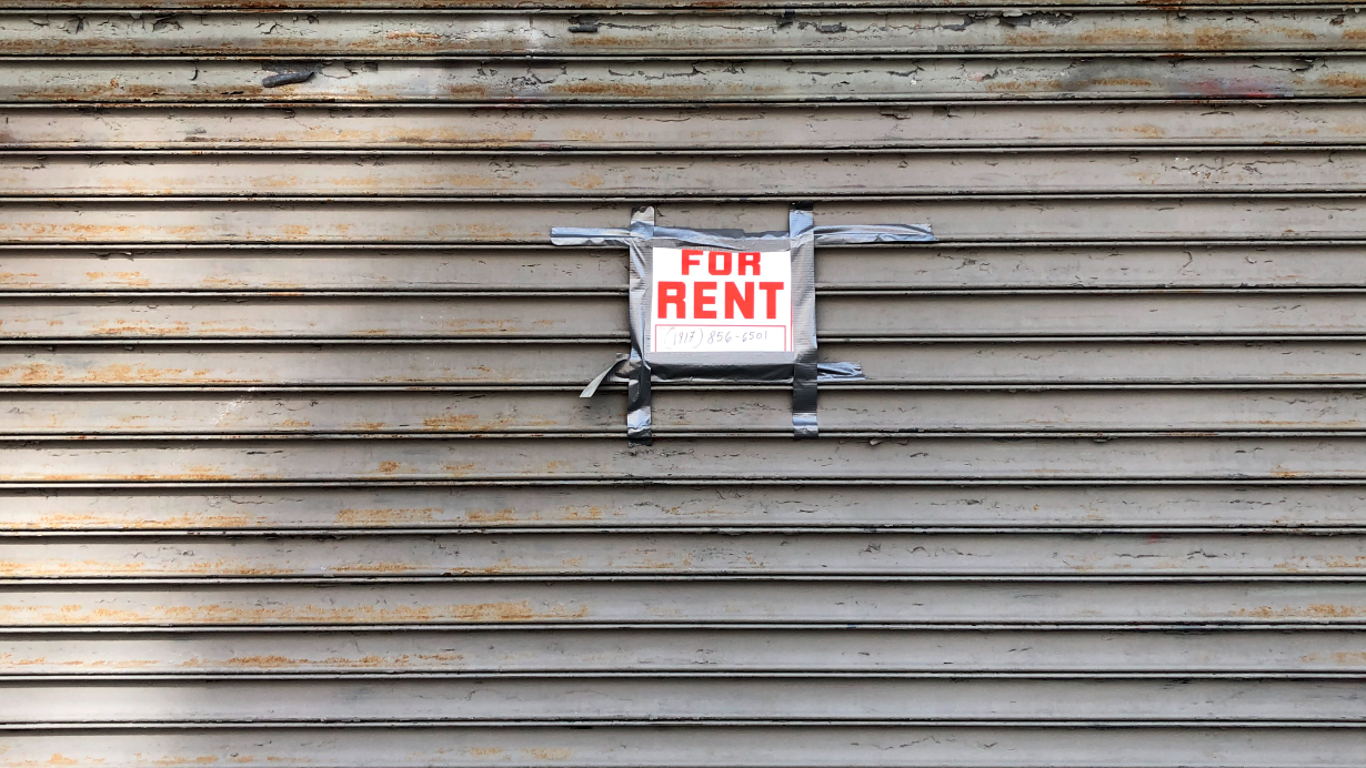 For Rent sign taped on gated storefront, Queens, New York