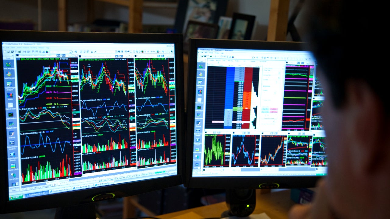 A picture of two trading screens with stock charts on them