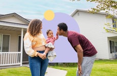 BIPOC couple holding a child from front of a house