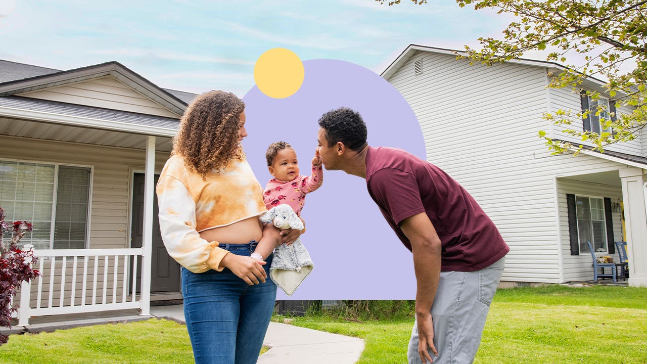 BIPOC couple holding a child from front of a house