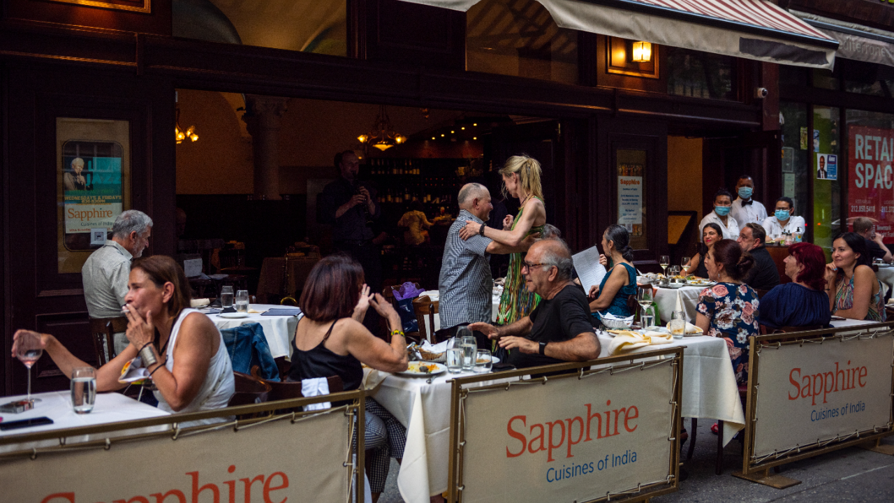 People dance at Sapphire's outdoor dining as musicians play live music on the Upper Wes Side on June 6 in New York City