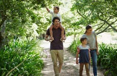 A young couple walk in the woods with their two kids