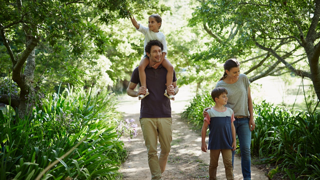 A young couple walk in the woods with their two kids