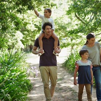 A young couple walk in the woods with their two kids