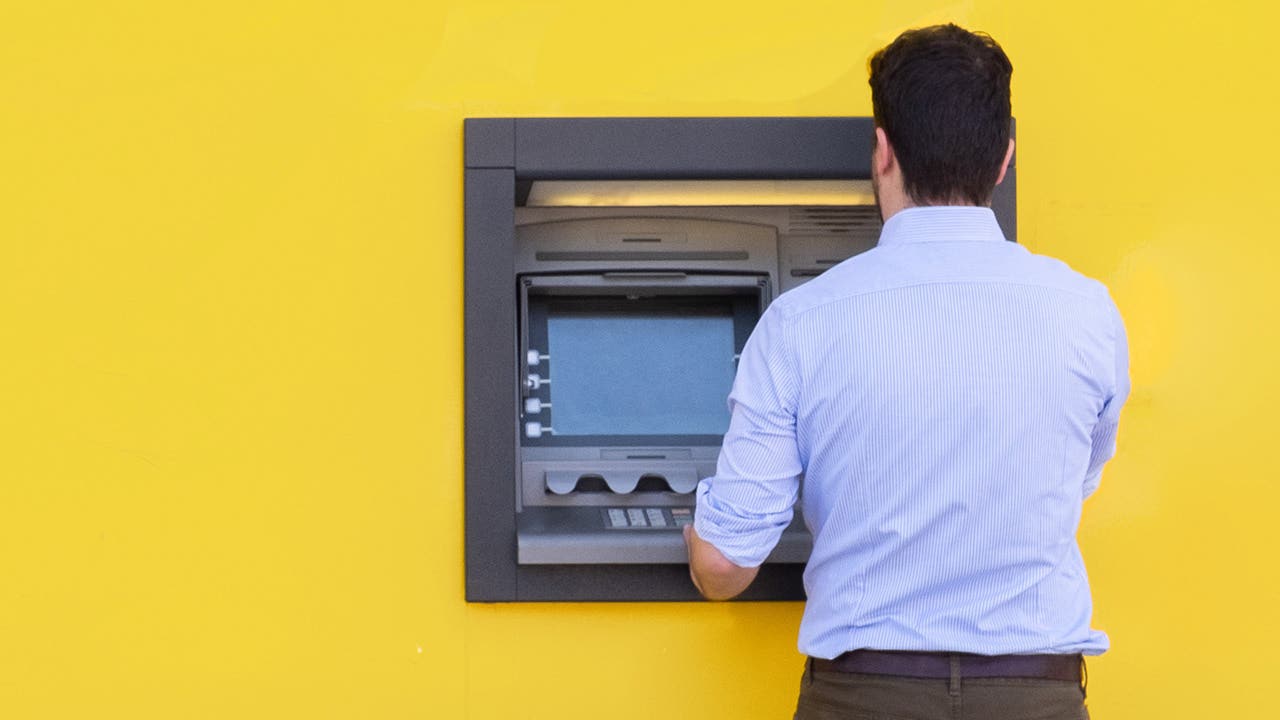 Man using a credit card in an atm for cash withdrawal