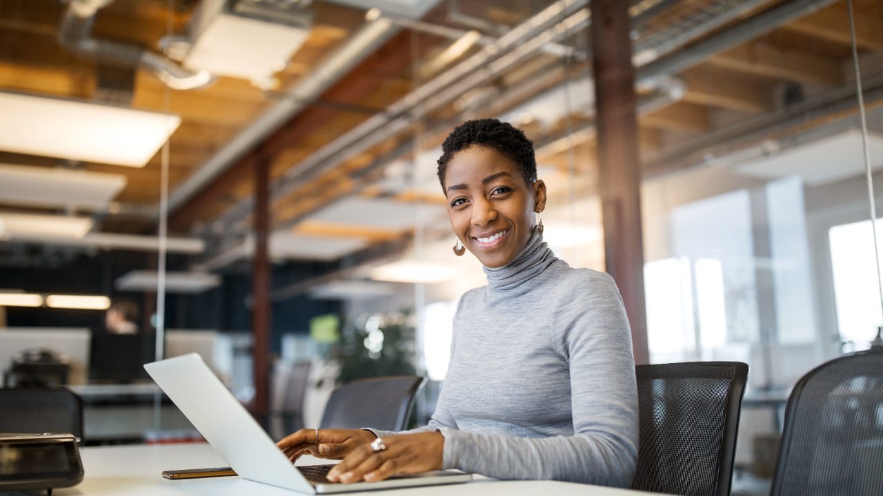 A woman works from a laptop at her office